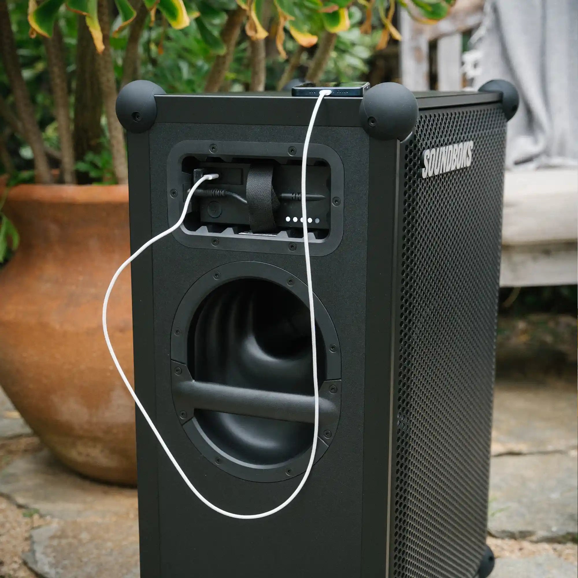 Smartphone getting charged with soundboks The Battery while playing