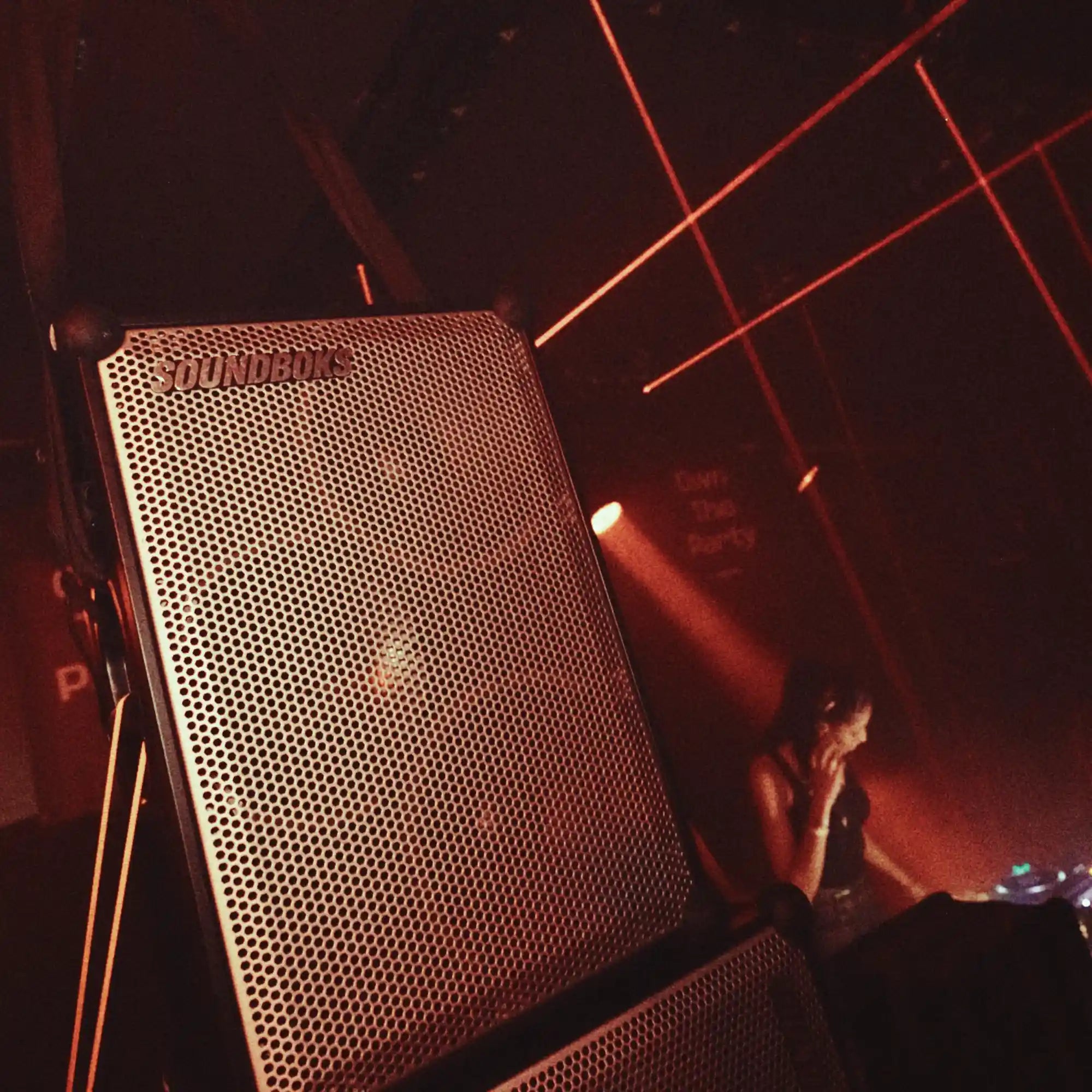 Metallic grey Soundboks 4 in red light.